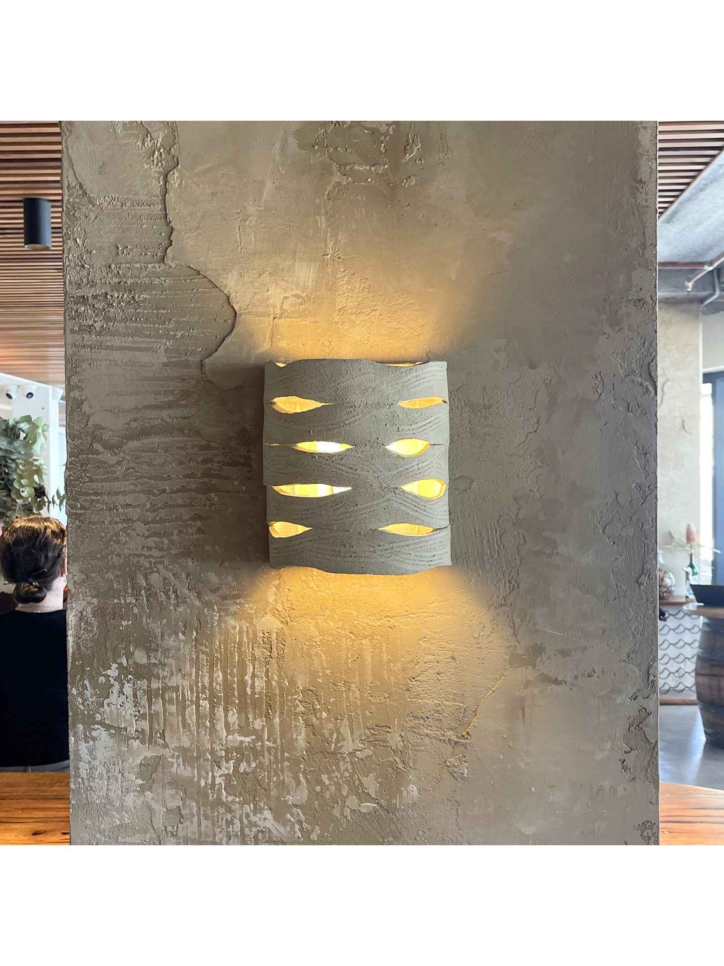 Panelled Wall Sconce installed on textured wall casting warm ambient light in interior architectural setting