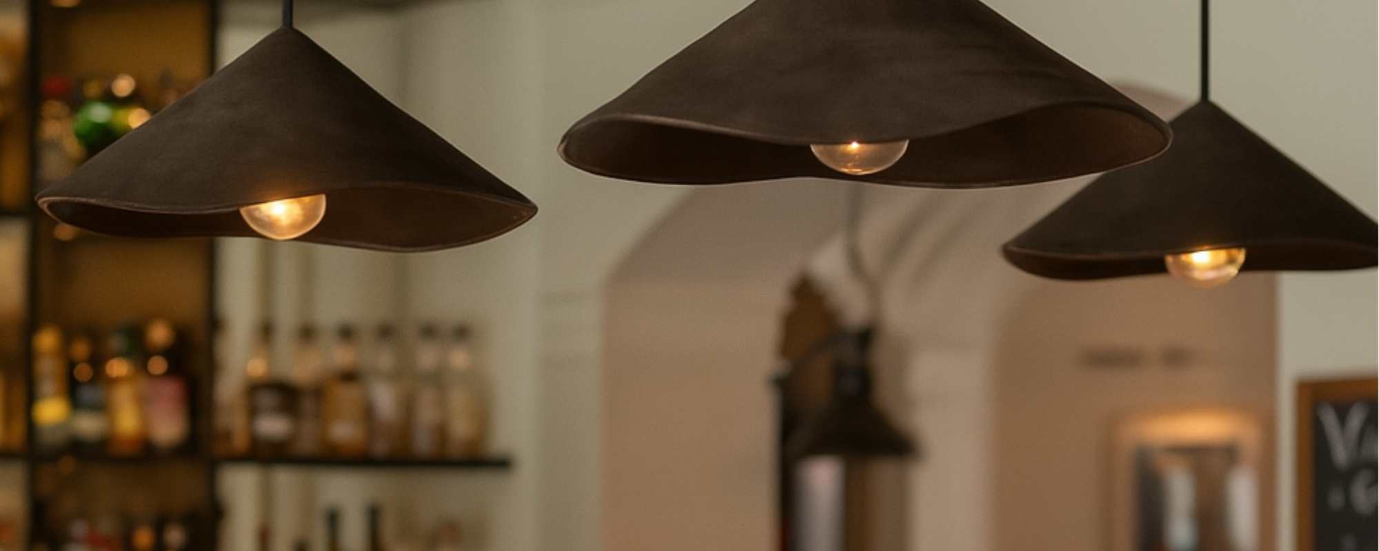 Fuji pendant lights suspended in hospitality venue featuring handmade ceramic shades with warm glow by Carver Lights