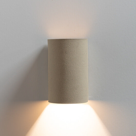 Beach Wall Sconce handcrafted ceramic wall light Australia lit showing warm ambient light cast upward and downward with natural clay texture
