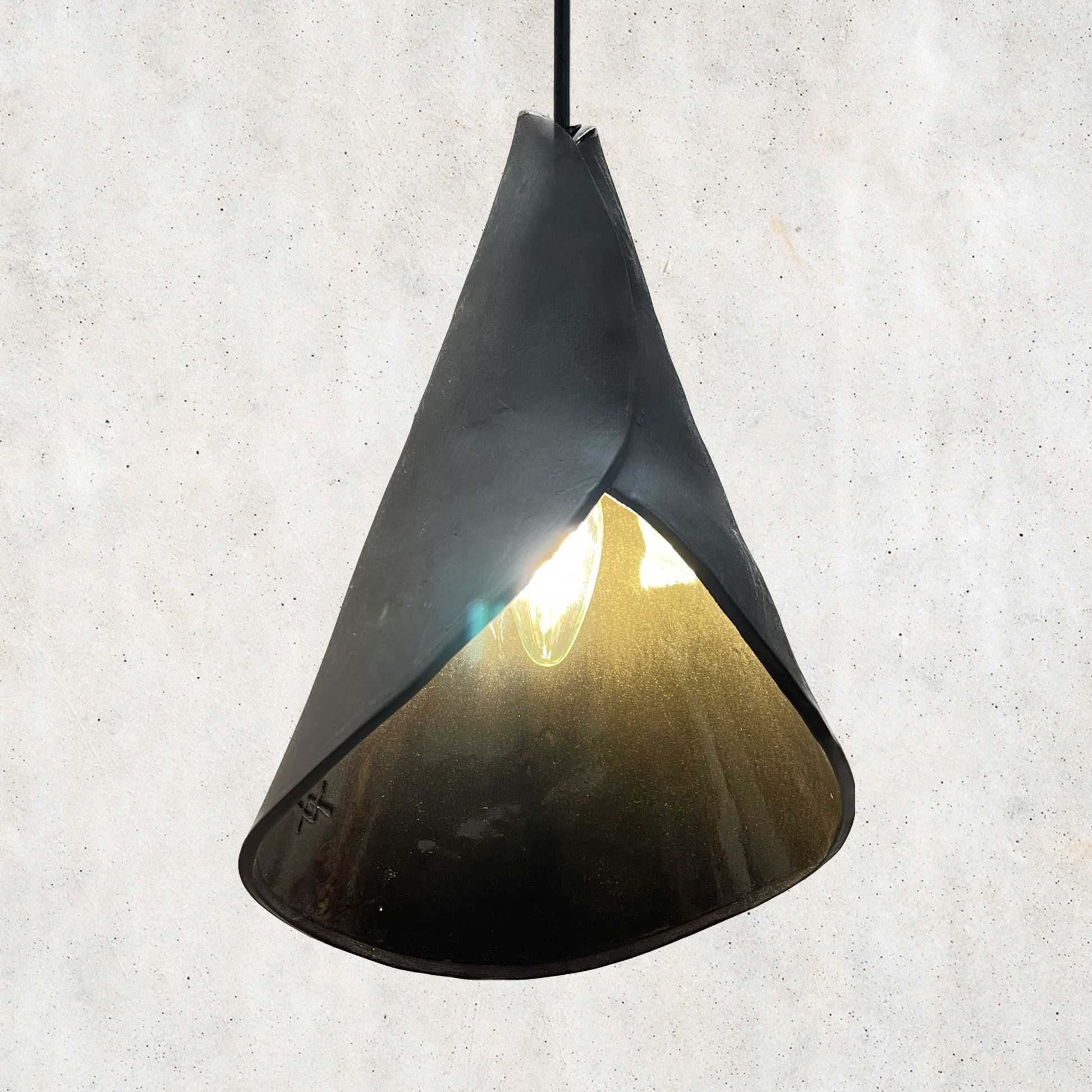 The Bouquet pendant handcrafted ceramic pendant light Australia in matte charcoal finish with sculptural folded form and warm internal glow