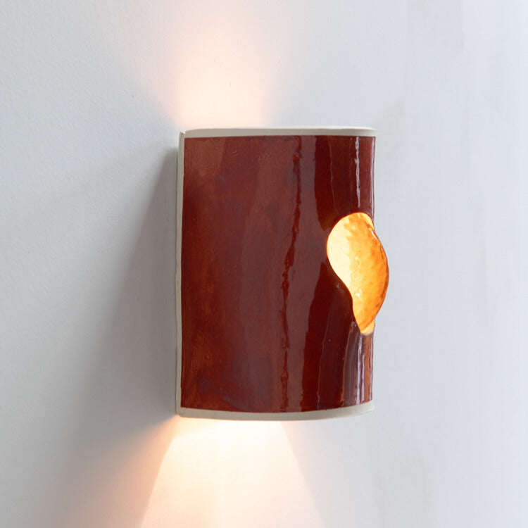 Burnt Orange Wall Sconce with Glass handcrafted ceramic wall light Australia lit from side angle showing glowing glass insert and warm ambient light