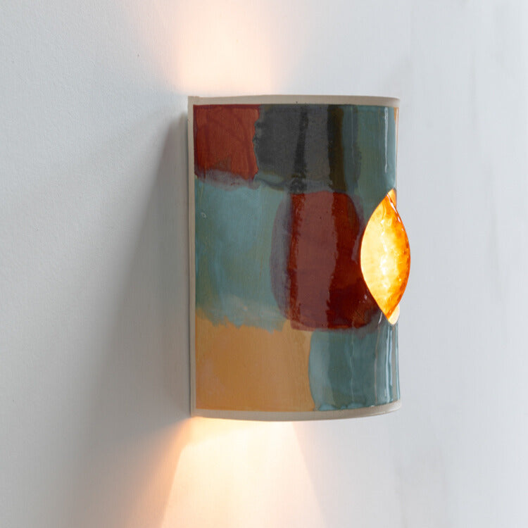 Carnival Wall Sconce with Glass handcrafted ceramic wall light Australia lit from side angle showing glowing glass insert and warm ambient light