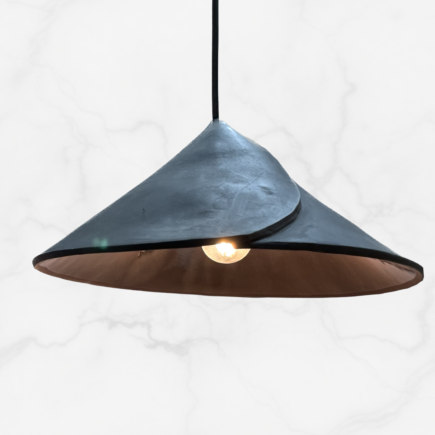 The Envelope pendant handcrafted ceramic pendant light Australia in matte charcoal finish with sculptural folded form and warm glow