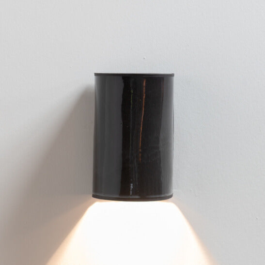 Gloss Black Wall Sconce handcrafted ceramic wall light Australia lit showing warm ambient light cast downward with glossy finish