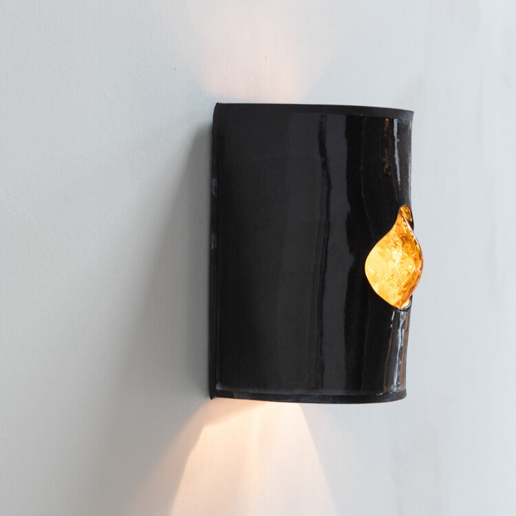 Gloss Black Wall Sconce with Glass handcrafted ceramic wall light Australia lit from side angle showing glowing glass insert and ambient light