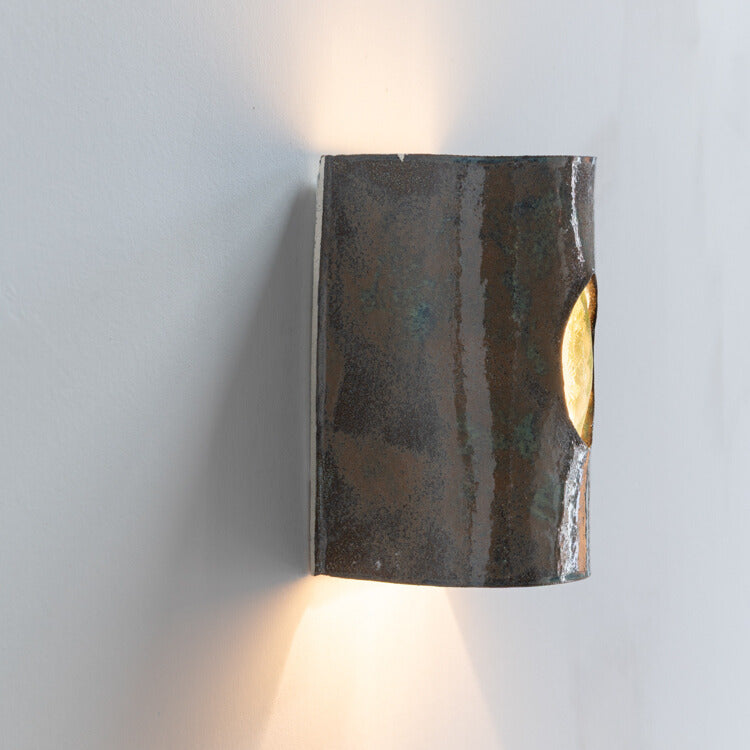 Green Stone Wall Sconce with Glass handcrafted ceramic wall light Australia lit from side angle showing glowing glass insert and ambient light