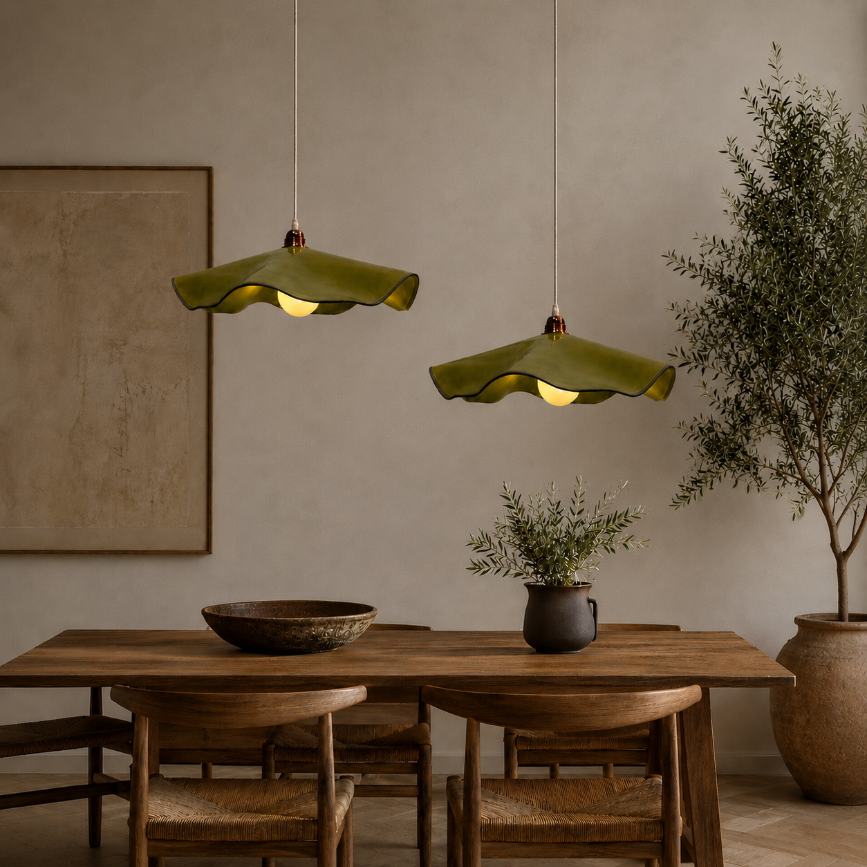 Two handcrafted Marilyn ceramic pendant lights in olive green glaze hanging at staggered heights above a timber dining table in a modern Australian home.