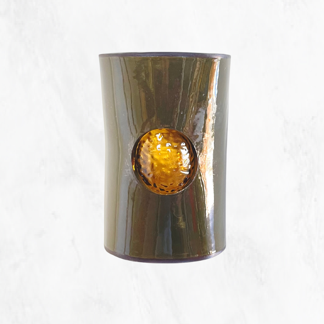 Front view of a handcrafted olive ceramic wall light featuring a textured amber glass insert, highlighting the rich olive glaze and warm amber glass against a clean white background.
