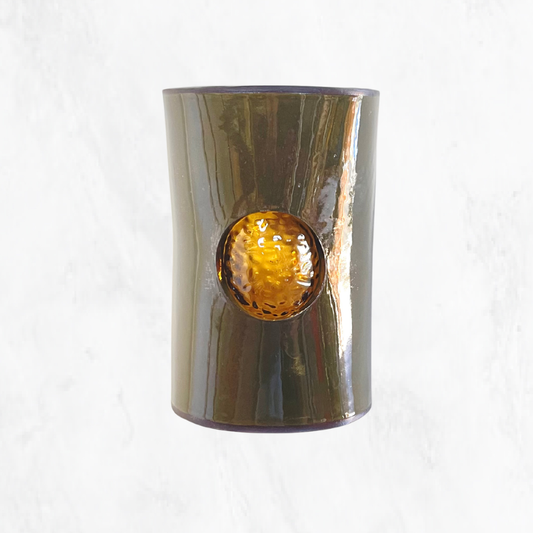 Front view of a handcrafted olive ceramic wall light featuring a textured amber glass insert, highlighting the rich olive glaze and warm amber glass against a clean white background.
