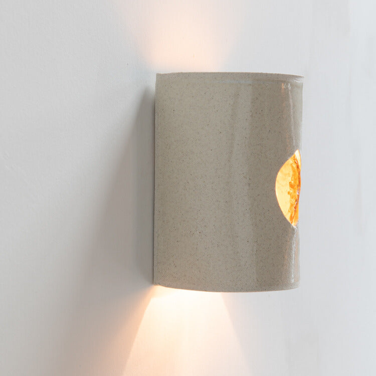 Stone Wall Sconce with Glass handcrafted ceramic wall light Australia lit showing warm ambient light and glowing glass insert from side angle
